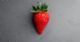 red strawberry on gray textile