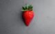 red strawberry on gray textile